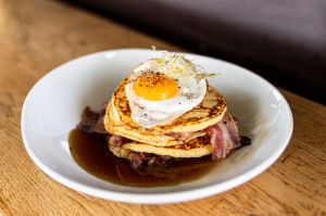 Bacon-Pancakes mit Spiegelei in einem weißen Teller