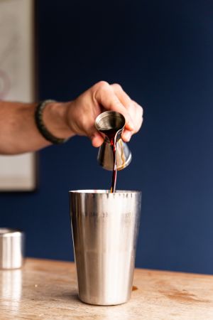 Die Hand eines Mannes befüllt einen Cocktail-Shaker